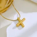 Detailed shot of the glossy gold bubble letter pendant necklace on white textured stone props. - Gold-Letter X