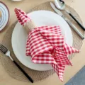 Detail shot of red and white checkered cloth napkin with rustic napkin ring for table decor. - 18x18 Inch / Red