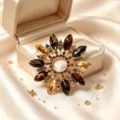 Primo piano ravvicinato di una spilla retrò con fiori in cristallo e pietre ambrate, dettaglio. - Stile Radioso Multistrato (款1)