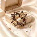 Gros plan d'une broche fleurie en cristal vintage, strass scintillants aux tons ambrés chauds. - Style Pétale en Spirale (款2)