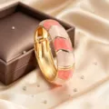 Detailed view of enamel wave cuff bracelet, pink and white color block open hinged zinc alloy jewelry. - Pink and White