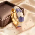 Vista di dettaglio ravvicinata del bracciale rigido aperto smaltato in lega di zinco. - Viola + Bianco