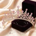 Close-up detail of a stunning gold tiara crown adorned with sparkling pink rhinestones. - KC Gold + Pink Rhinestone
