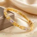 Gros plan détaillé du bracelet jonc floral en émail avec des strass scintillants. - Violet + Orange