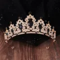 Nahaufnahme der goldenen Barock Krone mit funkelnden schwarzen Steinen und klaren Strasskristallen. - Gold + Schwarzer Zirkonia