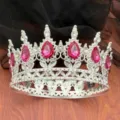Detailaufnahme der silbernen Barockkrone im Nahbereich mit leuchtenden pinken Kristallen. - Silber + Rosenroter Strass
