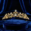 Primo piano dettagliato di un tiare dorato lucido con strass di cristallo scintillanti. - Oro + Zircone Bianco