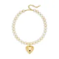 Primo piano di collana di perle in resina bianca con grande ciondolo a cuore dorato e catena. - Stile Cuore Perline Distanziatrici / Avorio