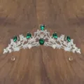 Detailed view of the silver tiara featuring green crystal stones and clear rhinestones. - Silver with Green Rhinestone