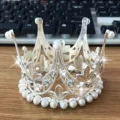 Silver alloy crown cake topper with pearls and leaves for kids birthday party decoration detail. - Silver