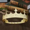 Detail shot of a vintage gold metallic king crown prop, featuring ornate embossed patterns. - Gold