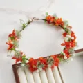 Dettaglio di corona di fiori da sposa in stile bosco con fiori arancioni per foto. - Arancione