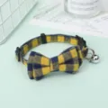 Detail view of the yellow plaid pet collar with a cute bow tie and small silver bell. - Yellow