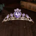 Primo piano della tiara dorata per bambini con strass a cuore viola e cristalli scintillanti. - Stile Oro con Strass Viola