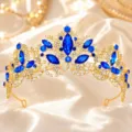 Detailed shot of a luxurious gold baroque tiara with sparkling blue and clear rhinestones. - Gold with Royal Blue Rhinestone