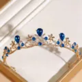 Gedetailleerd overzicht van de elegante gouden tiara met strass-stenen en prachtige bloemdetails. - KC Goud + Blauwe Strass