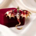 Primo piano della spilla drago vintage con ali smaltate rosse e strass di cristallo scintillanti. - Stile Rosso