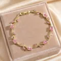 Detail view of a luxury gold-plated vine bracelet featuring sparkling pink cubic zirconia stones. - Nude Pink