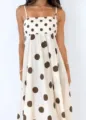 Detailed macro view of white spaghetti strap summer dress with brown polka dot pattern - Russet