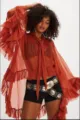 Close-up of terracotta sheer blouse with tiered ruffled sleeves and pussy-bow tie - Orange