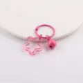 Nahaufnahme eines rosa Stern-Anhängers und Glocken-Schlüsselanhängers - Fuchsia