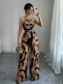 Full-length detail of a halter-neck wide-leg jumpsuit with brown and black abstract print. - Tan