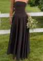 Detailed view of brown strapless maxi dress with ruched waist in garden setting - S / Dresses / Coffee