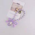 Cordino per telefono intrecciato viola con grazioso fiocco e pompon, accessorio elegante. - Viola