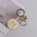 Goldfarbener Metallschlüsselanhänger mit Herz-Anhänger und Holzetikett für Taschen. - Schleife Natürliches Holz