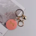 Schlüsselanhänger im Handmade-Stil mit rosa Holzanhänger, goldenem Ring und Herzanhänger. - Schleifenform Koreanisches Rosa