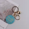 Ins-Stil handgemachter blauer Holzschlüsselanhänger mit goldener Metallhardware und Herz. - Blaues Smiley-Gesicht