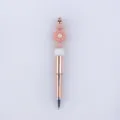 Nahaufnahme Detail des DIY Perlenstifts mit süßem Silikon Gänseblümchen Anhänger und Metall. - Rosarot