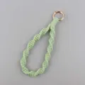 Portachiavi da polso in macramè fatto a mano in corda di cotone verde chiaro con anello dorato. - verde chiaro