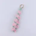 Handmade floral crochet keychain detail, cute pink and green daisy macrame strap design. - Pink