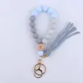 Silicone beaded wristlet keychain with wooden charm and leather tassel, ideal for daily use. - Light Blue