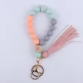 Silicone beaded wristlet keychain with wooden eye bead, leather tassel and gold metal ring. - Light Green
