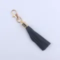 Schwarzer Leder Quasten Schlüsselanhänger mit goldenem Karabiner und Metallkappe für Tasche. - Schwarz