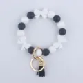 Portachiavi con braccialetto di perline in silicone nero e bianco con fiocchi e anello. - Bianco
