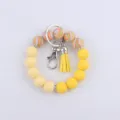 Détail de porte-clés en perles de silicone avec perles colorées, fermoir et pompon. - Série Jaune
