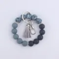 Détail de porte-clés bracelet en perles de silicone avec dégradé gris et gland en cuir. - Gris