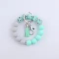 Porte-clés bracelet en perles de silicone avec pompon et fermoir métallique pour usage quotidien. - Vert