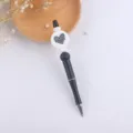 Close-up detail of DIY beadable ballpoint pen showing black body and silicone heart bead decoration. - Love You Mom