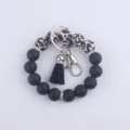 Détail de porte-clés bracelet en perles de silicone avec perles imprimé léopard et gland noir. - Imprimé léopard