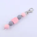 Detailed view of silicone beaded keychain with pink and grey beads and cute rainbow arch charm. - Pink