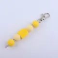 Detailed view of DIY silicone bead keychain charm with colorful rainbow pendant and rhinestones. - Yellow