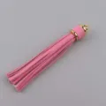 Dettaglio nappa in pelle rosa, cappuccio in metallo dorato, accessorio bracciale gioiello. - Rosa