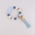 Llavero pulsera de cuentas de silicona azul con bonito dije de luna y borla de cuero. - Azul claro