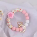Silicone bead wristlet keychain with pink flower charm and gold heart clasp, cute style. - Begonia Pink