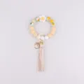 Silikon Perlen Schlüsselanhänger Armband mit süßer Gänseblümchen Blume und Quaste in gelb. - Begoniengelb