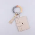 Detalle del llavero con pulsera de cuentas de silicona y tarjetero de cuero PU. - Beige